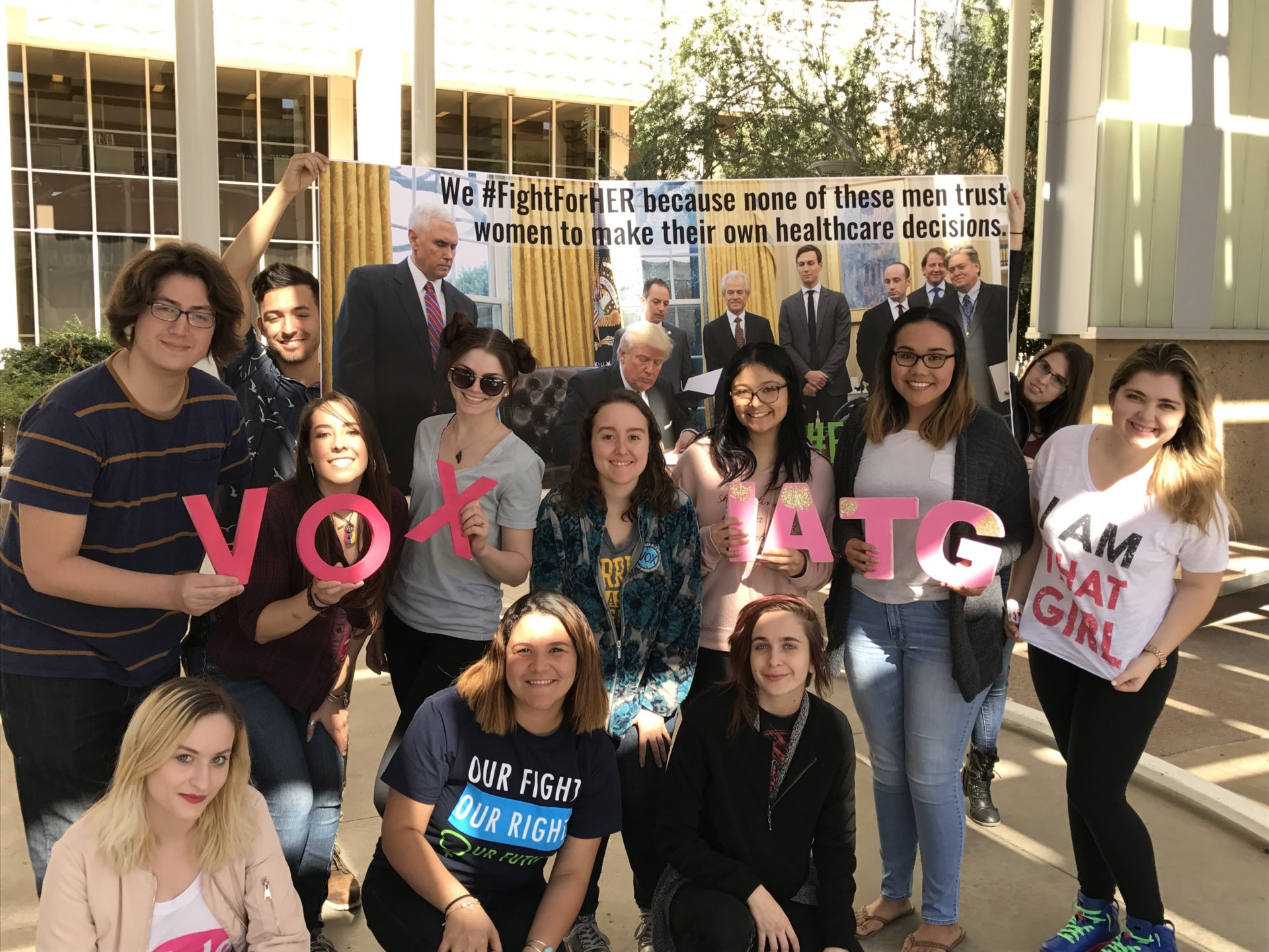 a group of population connect action supporters holding signage encouraging people to vote.