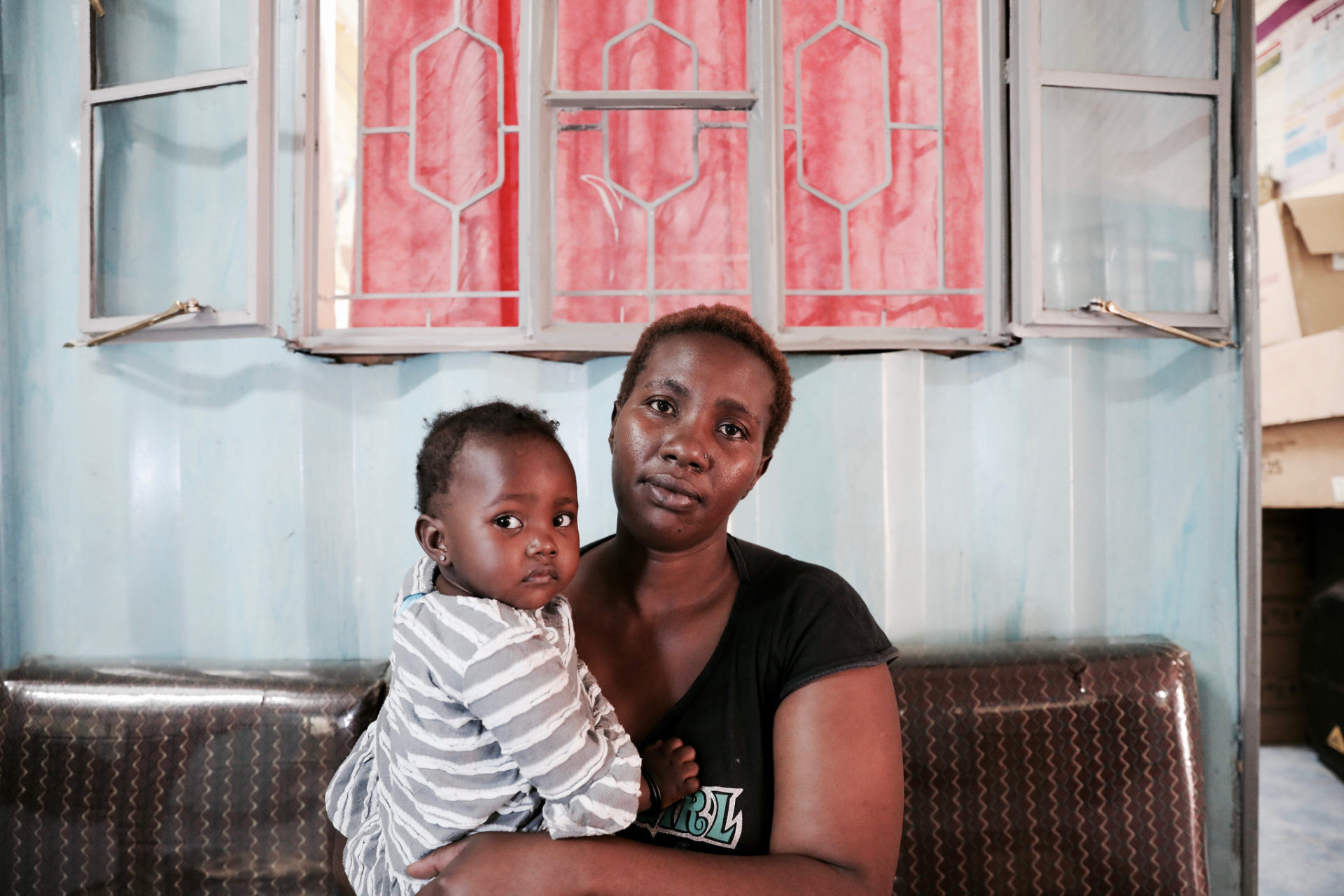 Mary M. waits with her child at the FHOK clinic in Kibera.